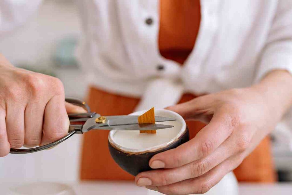 a women cutting the wooden Candle Wick